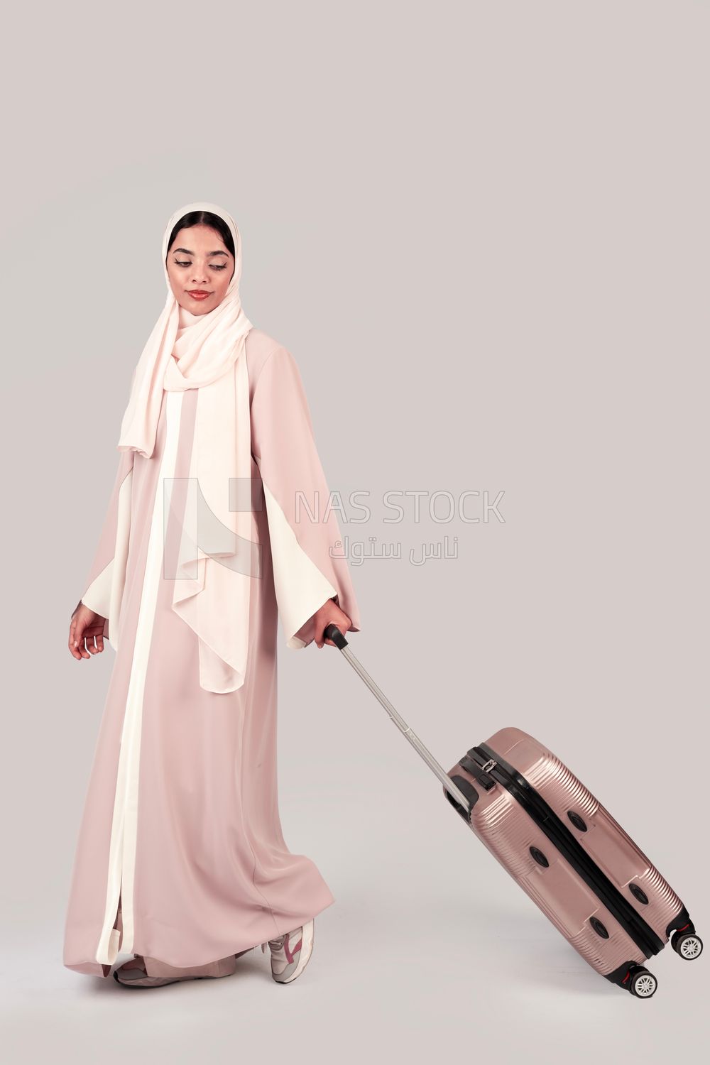Veiled Gulf girl with suitcase