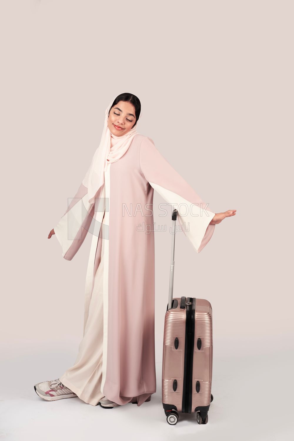 Veiled Gulf girl with suitcase