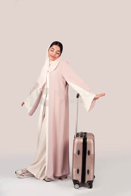 Veiled Gulf girl with suitcase