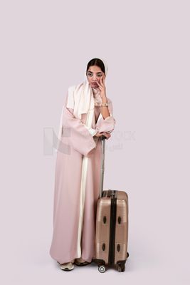 Veiled Gulf girl with suitcase