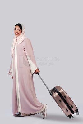 Veiled Gulf girl with suitcase