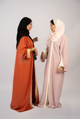 Two Gulf girls wearing modern Gulf abayas