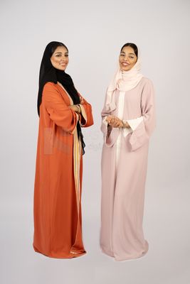 Two Gulf girls wearing modern Gulf abayas