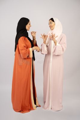 Two Gulf girls wearing modern Gulf abayas