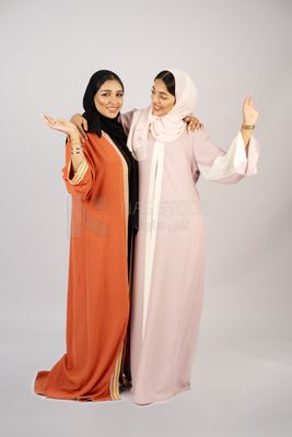 Two Gulf girls wearing modern Gulf abayas