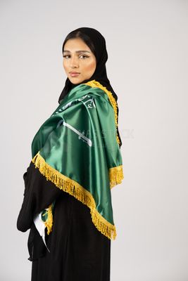 Saudi girl wearing the Gulf abaya and placing the Saudi flag on her shoulder