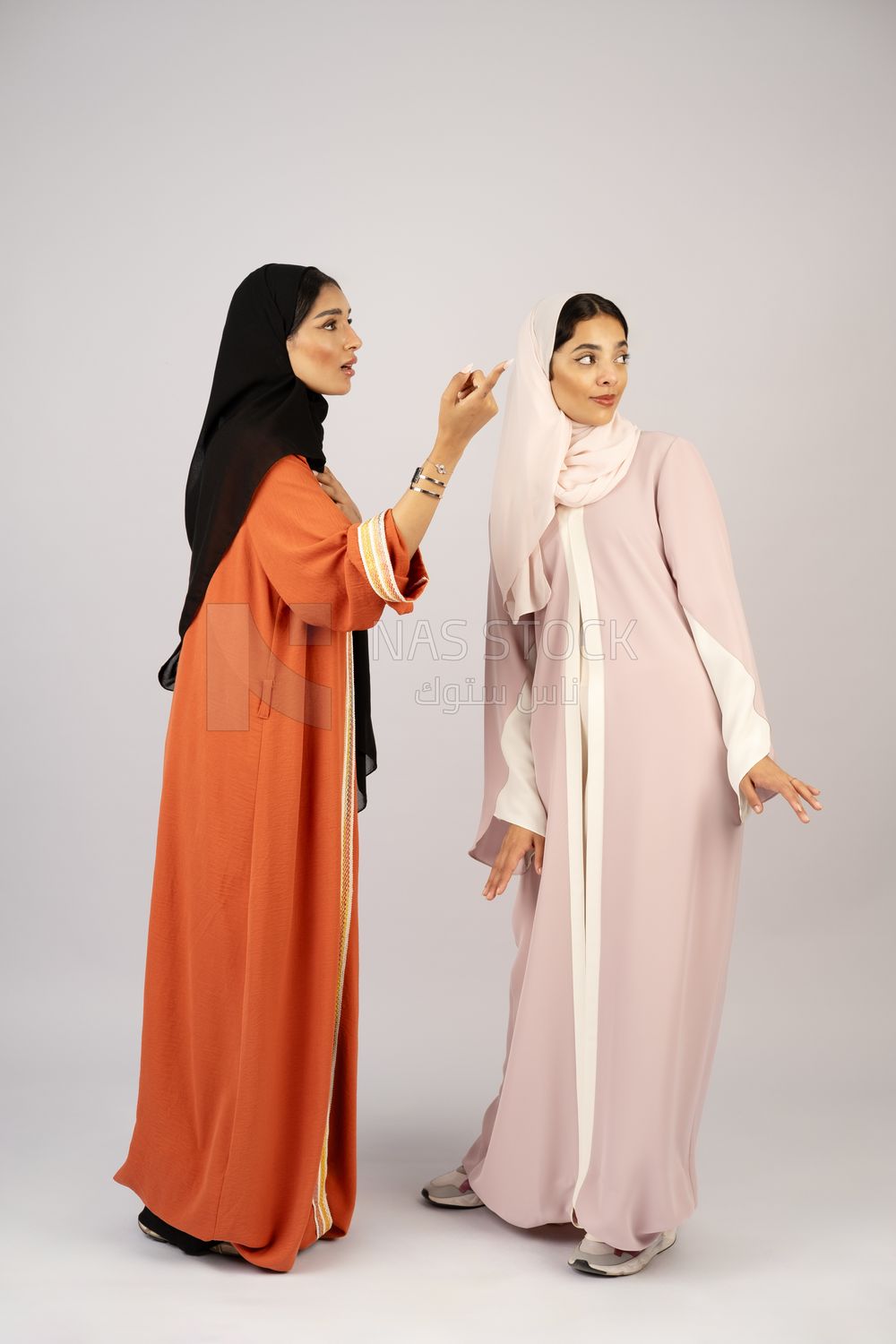 Two Gulf girls wearing modern Gulf abayas