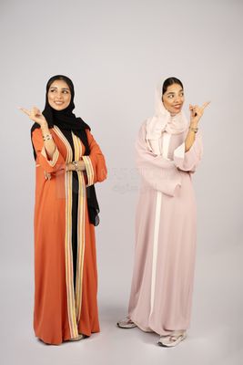 Two Gulf girls wearing modern Gulf abayas