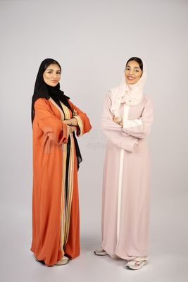Two Gulf girls wearing modern Gulf abayas