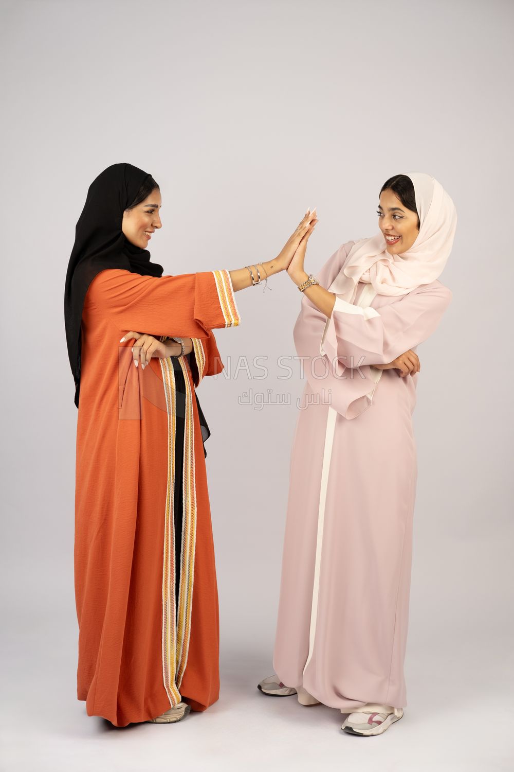Two Gulf girls wearing modern Gulf abayas
