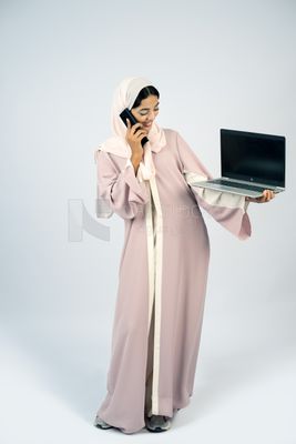 Gulf girl holding a laptop with a phone