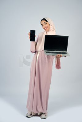 فتاة خليجية تحمل لاب توب مع هاتف