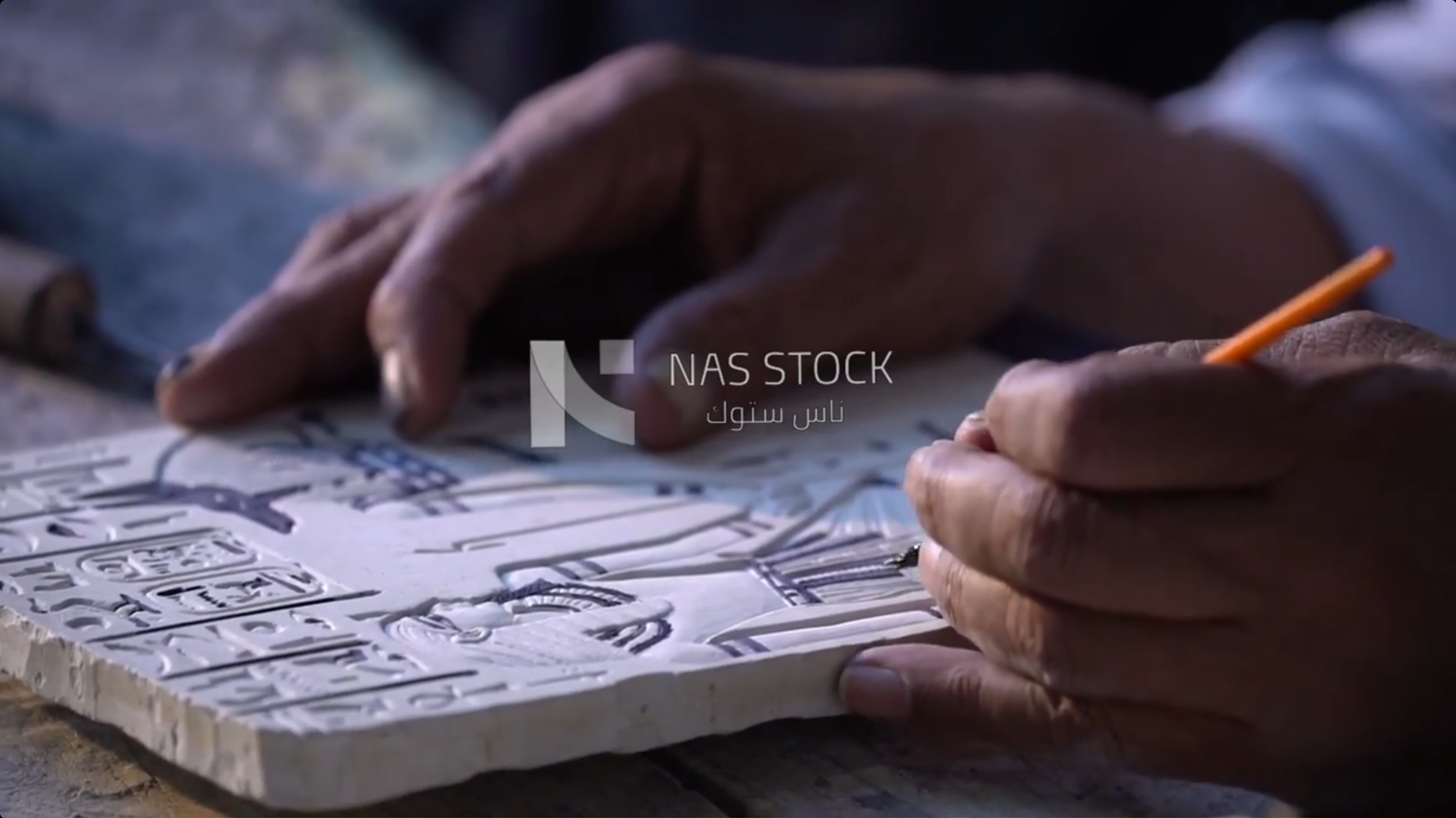Worker sitting on the floor, carving a statue