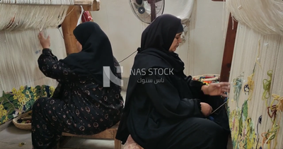 Two Egyptian women making handmade carpet