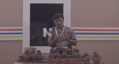 Man making pots using a pottery wheel