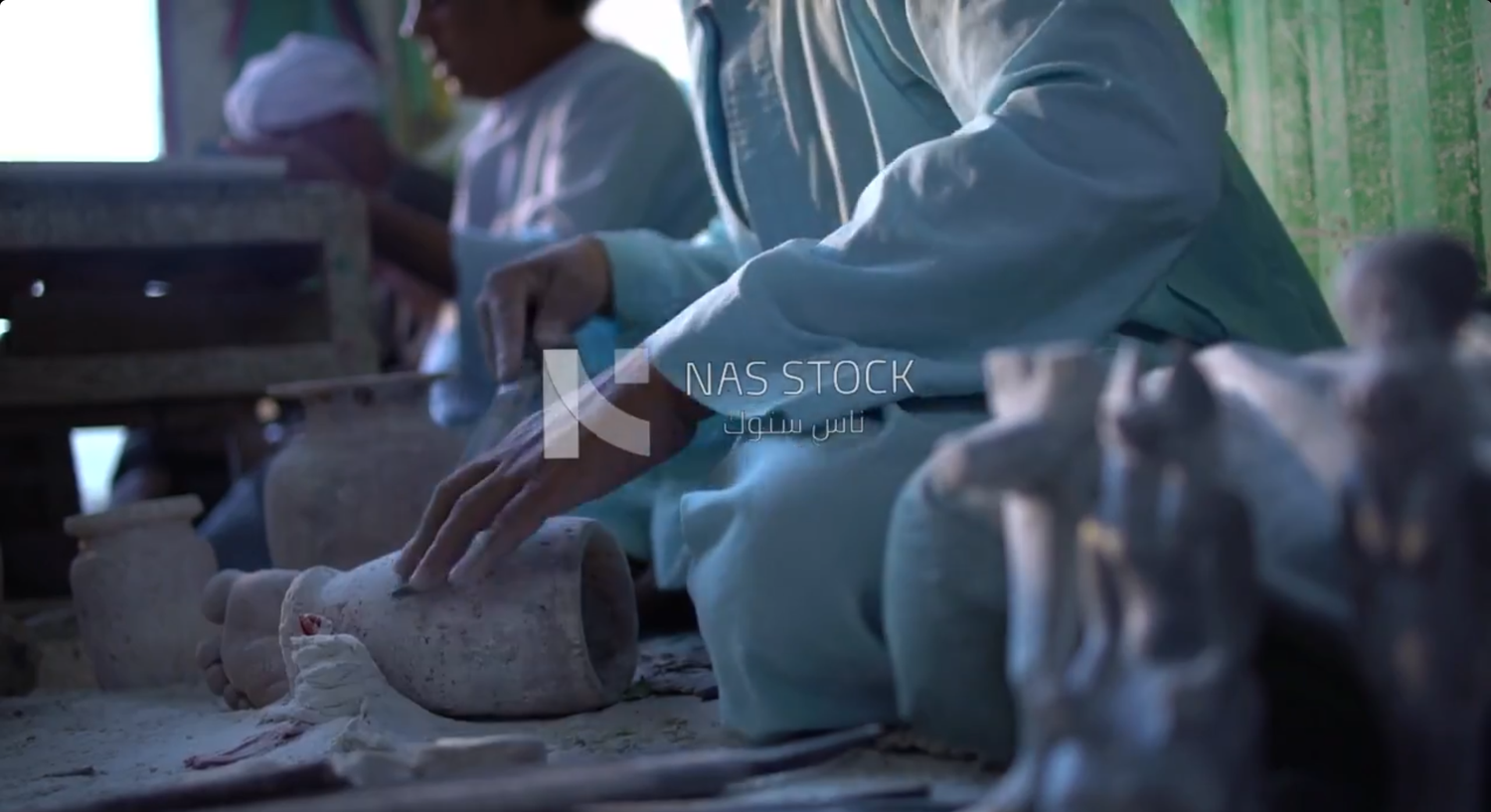 Worker sitting on the floor, carving pots