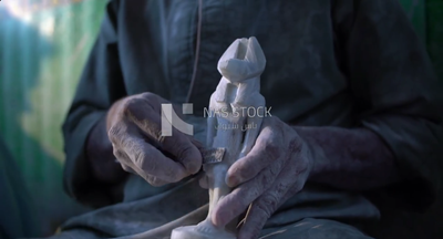 Worker sitting on the floor, carving a statue