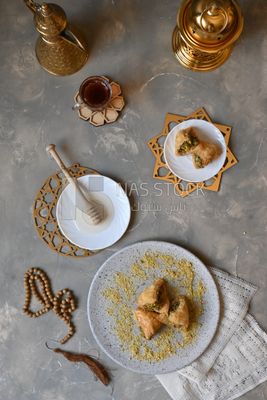 Baklava with nuts, a cup of tea, a plate of honey, oriental Arabic sweets, Ramadan sweets