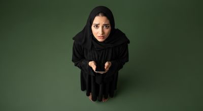 Gulf woman holding a mobile phone with a blank black screen