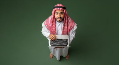 Gulf man holding a laptop and looking up