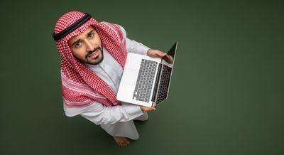 Gulf man holding a laptop and looking up