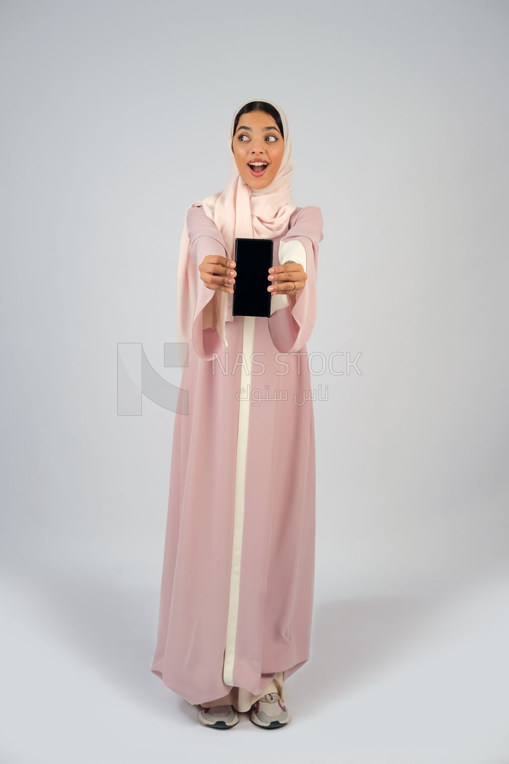 Gulf girl holding a mobile phone with a blank black screen