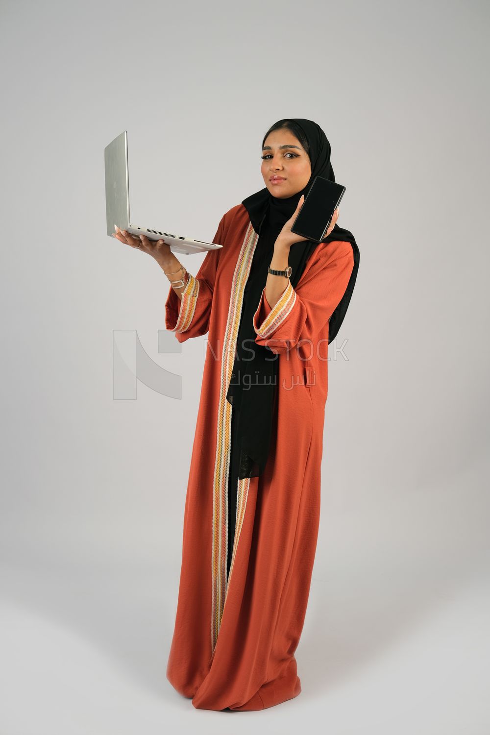 Gulf girl holding a phone and a laptop