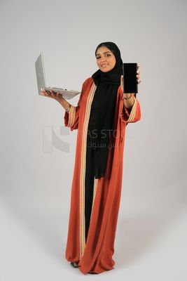 Gulf girl holding a phone and a laptop with a blank black screen