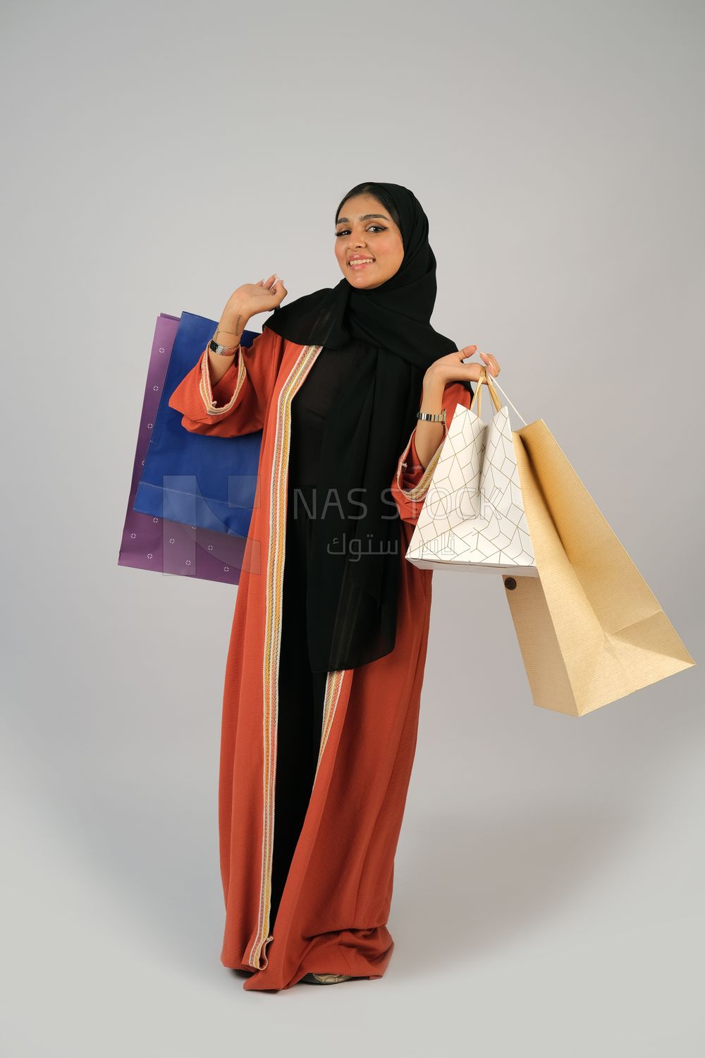 Gulf girl carrying colorful shopping bags