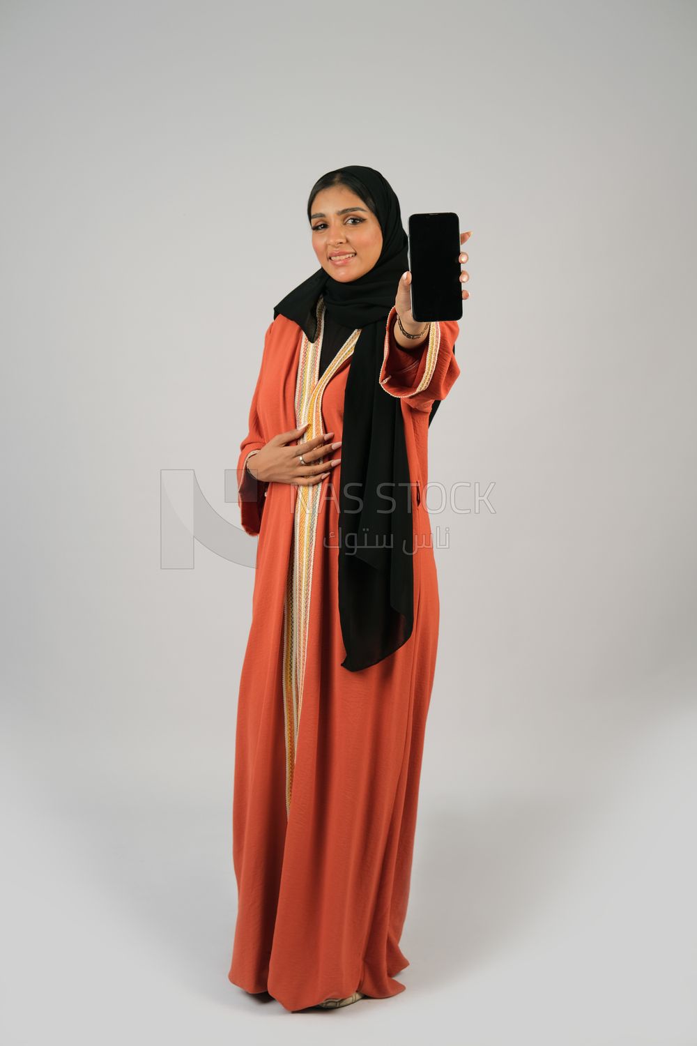 Gulf girl holding a mobile phone with a blank black screen