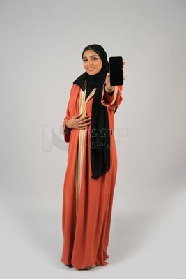 Gulf girl holding a mobile phone with a blank black screen