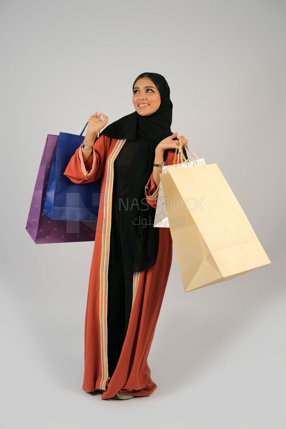 Gulf girl carrying colorful shopping bags