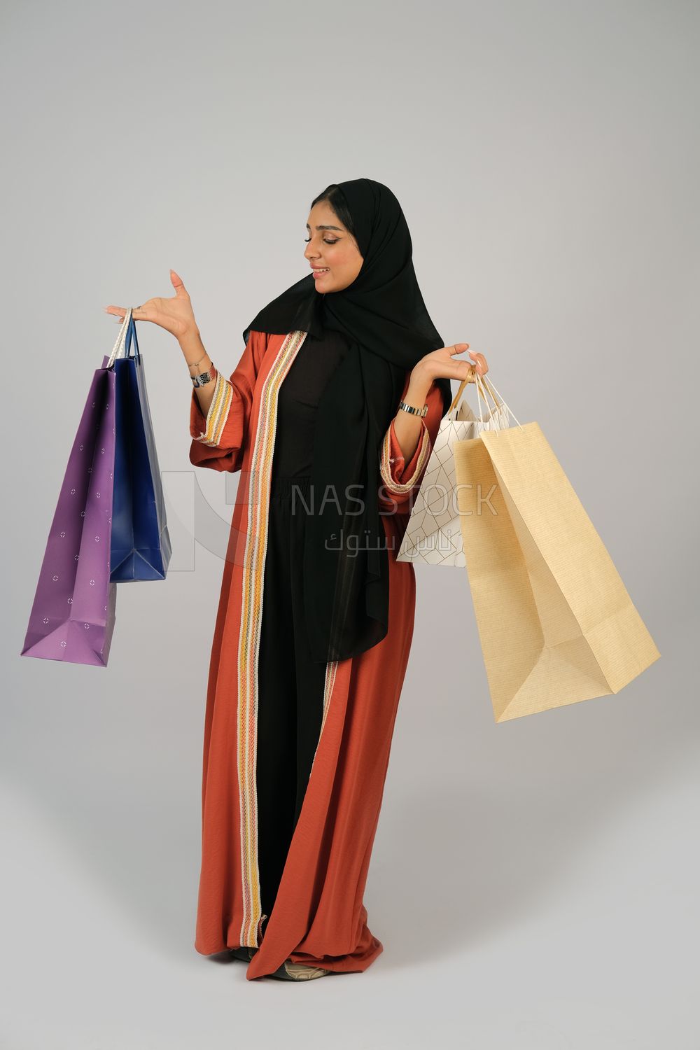 Gulf girl carrying colorful shopping bags