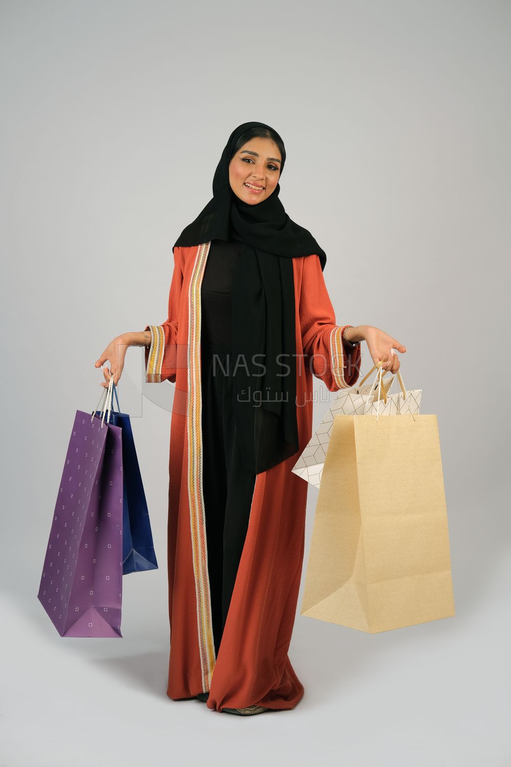 Gulf girl carrying colorful shopping bags