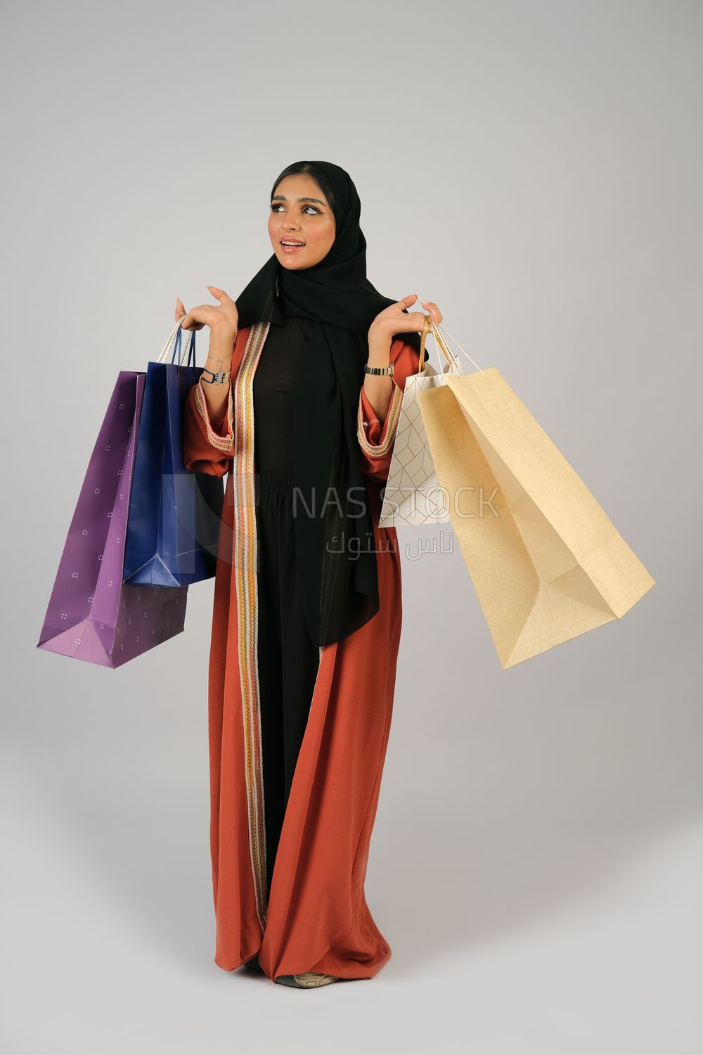 Gulf girl carrying colorful shopping bags
