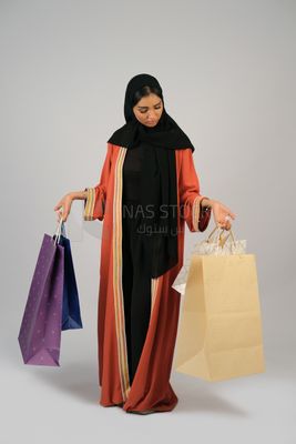 Gulf girl carrying colorful shopping bags