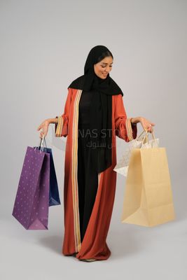 Gulf girl carrying colorful shopping bags