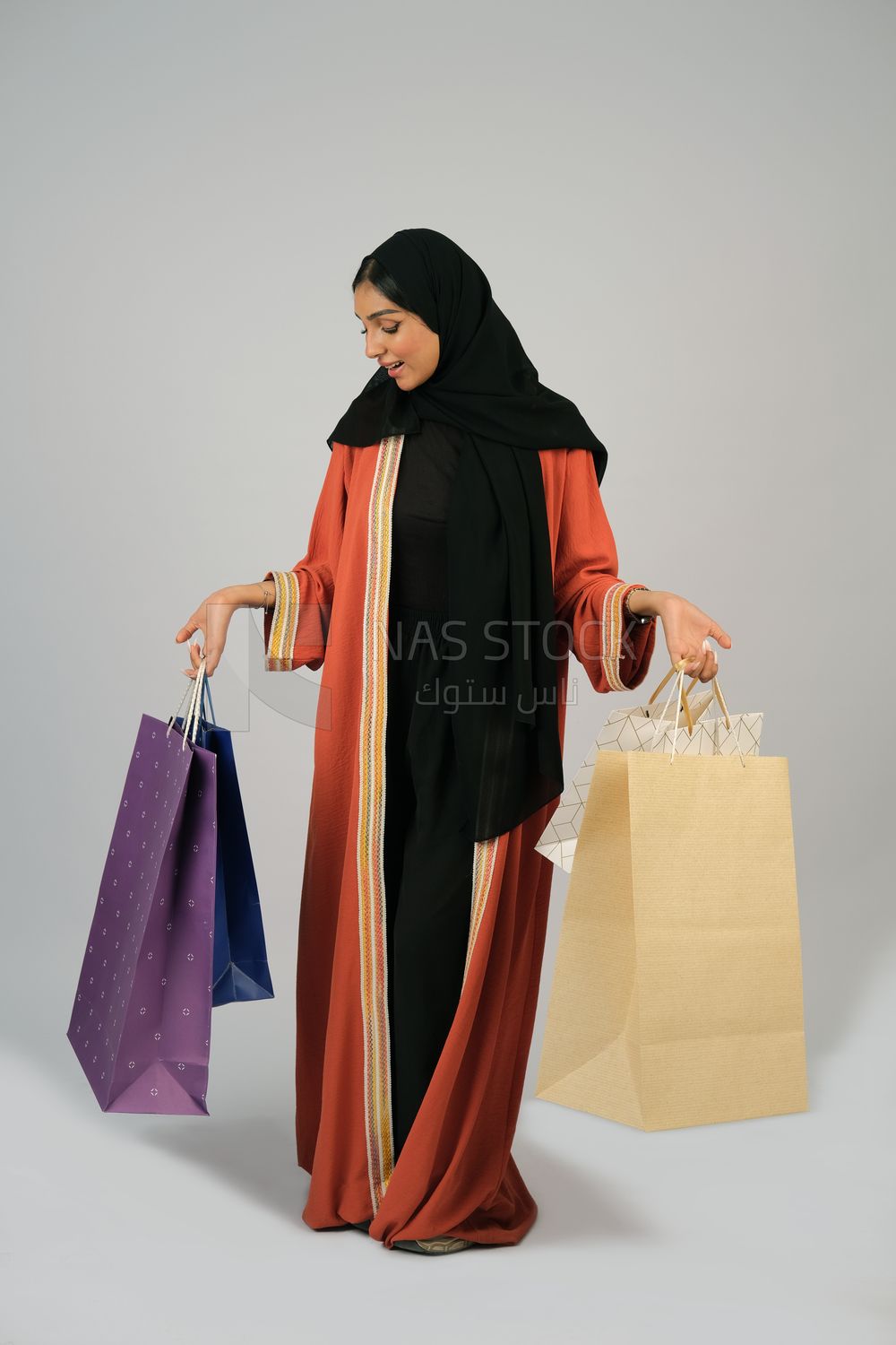 Gulf girl carrying colorful shopping bags