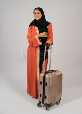 Saudi Gulf girl holding a suitcase in her hand