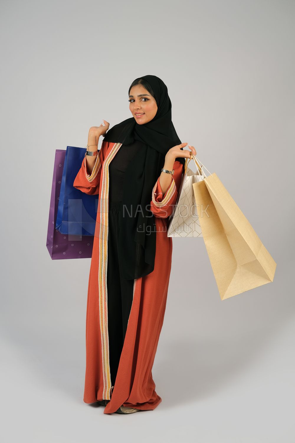 Gulf girl carrying colorful shopping bags