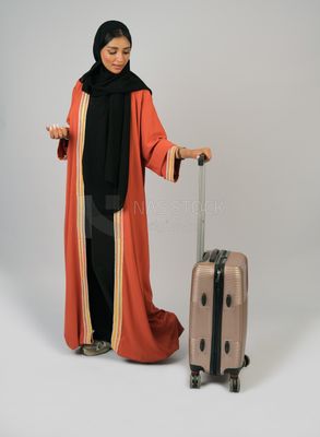 Saudi Gulf girl holding a suitcase in her hand