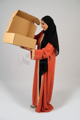 Saudi Gulf girl holding a cardboard delivery box