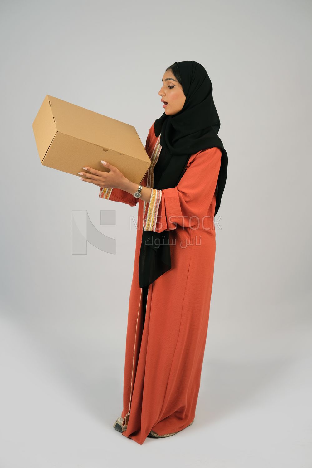 Saudi Gulf girl holding a cardboard delivery box