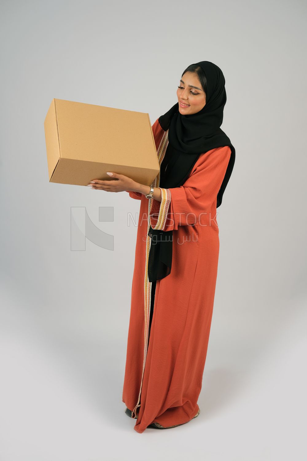 Saudi Gulf girl holding a cardboard delivery box