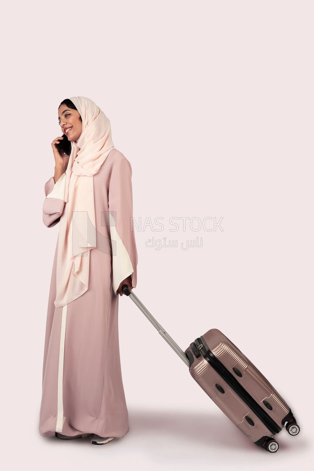 Gulf woman holding suitcase and talking on phone