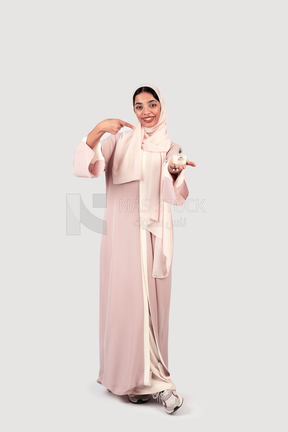 Gulf woman holding a bottle of perfume in her hand