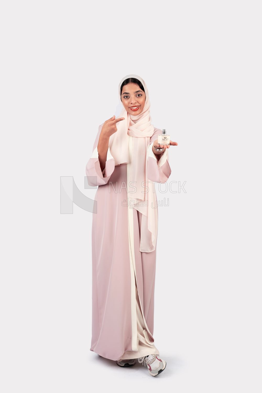 Gulf woman holding a bottle of perfume in her hand