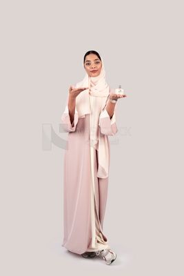 Gulf woman holding a bottle of perfume in her hand