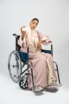 Girl sitting in wheelchair holding white card