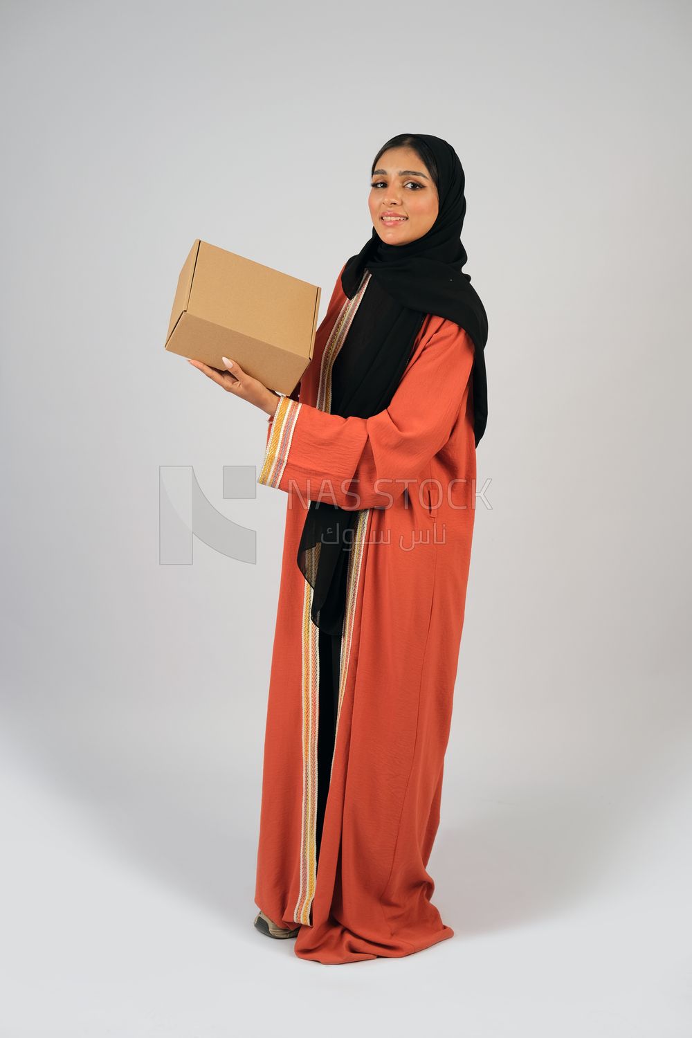 Saudi Gulf girl holding a cardboard delivery box